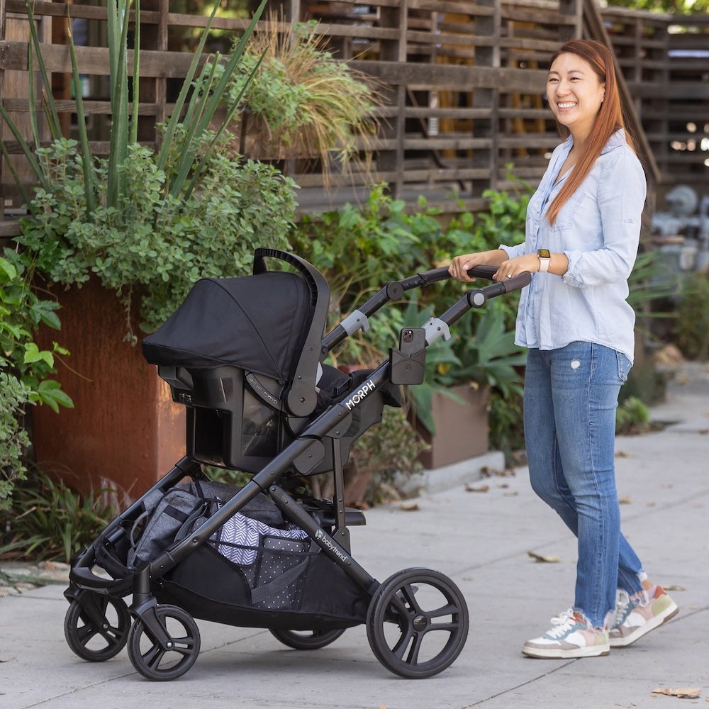 A parent out with their child in a Baby Trend Morph modular stroller