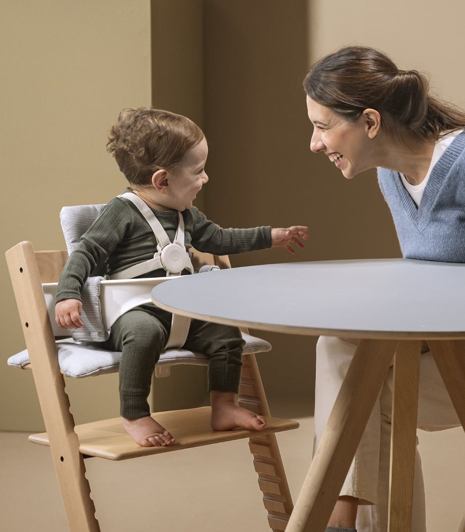 A child held by the Stokke Harness V2 on a Tripp Trapp Baby Set 2