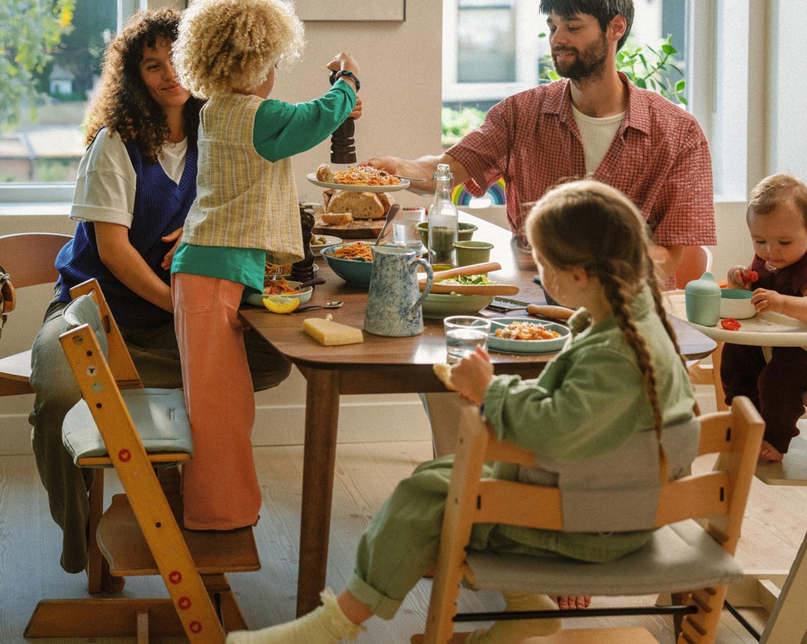 Family meal with a child on a Tripp Trapp chair and a baby in a Tripp Trapp high chair, all at one table